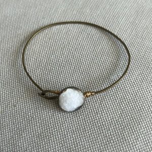 Gold colored bracelet with white stone